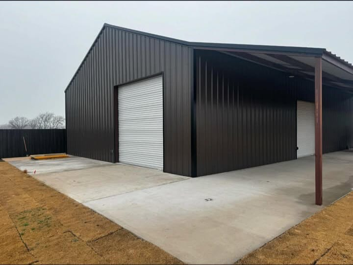 Side elevation of a metal building with covered walkway and concrete slab
